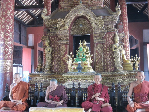 Une reproduction du bouddha d'émeraude de Bangkok, avec les statues de cire des anciens dirigeants du monastère